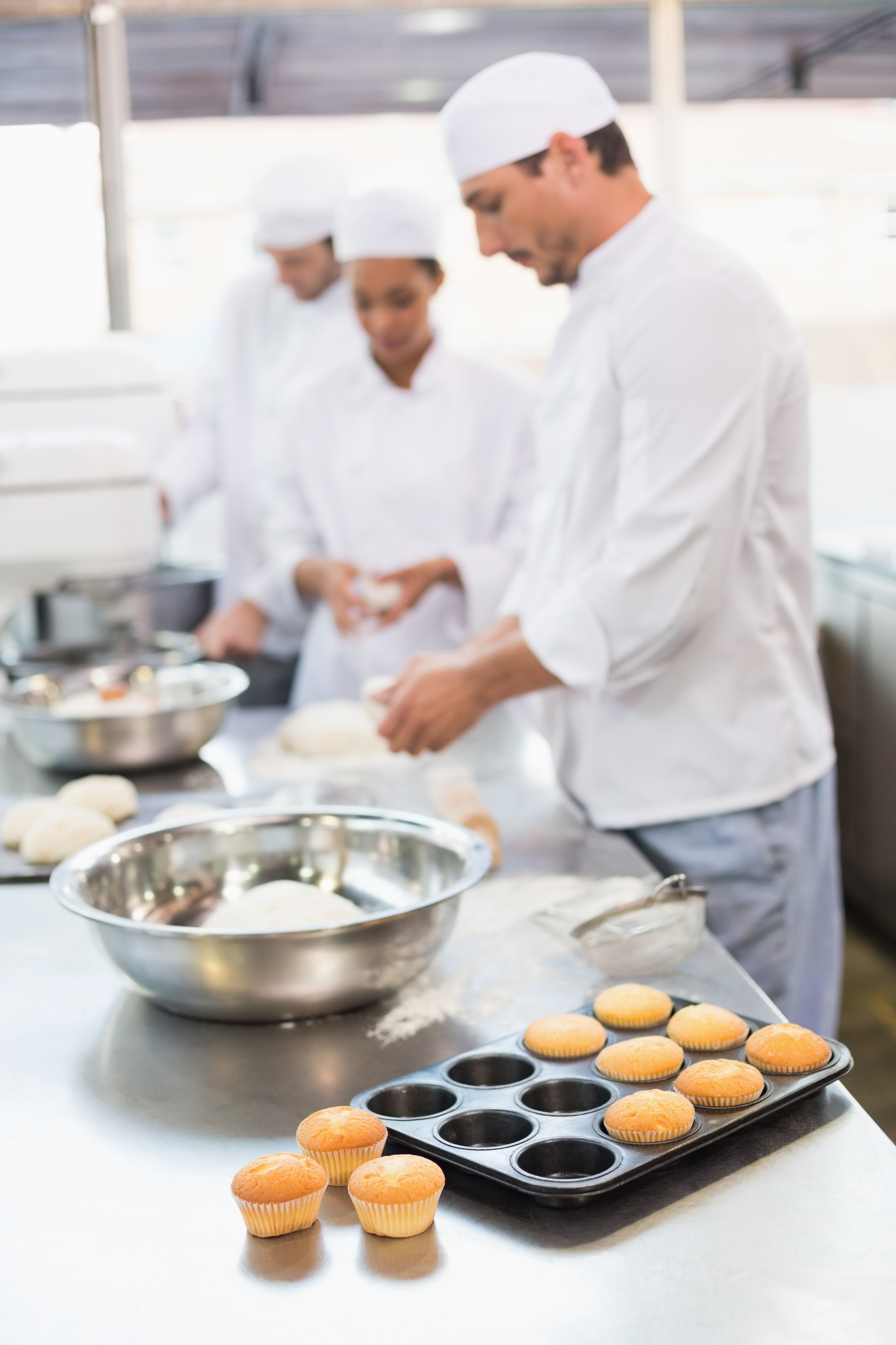 Panaderos trabajando en la cocina preparando alimentos